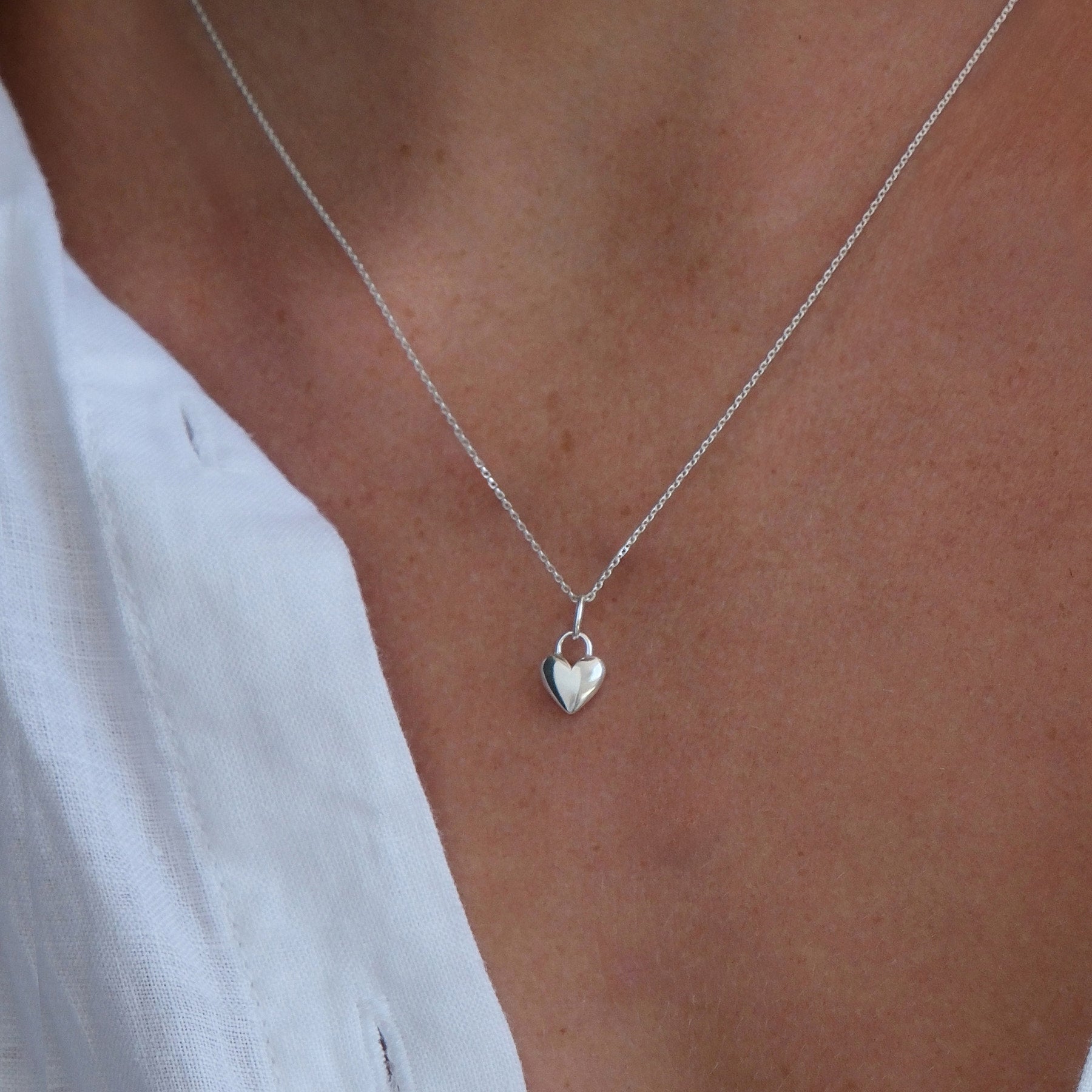 Close up image of a sterling silver heart charm necklace 